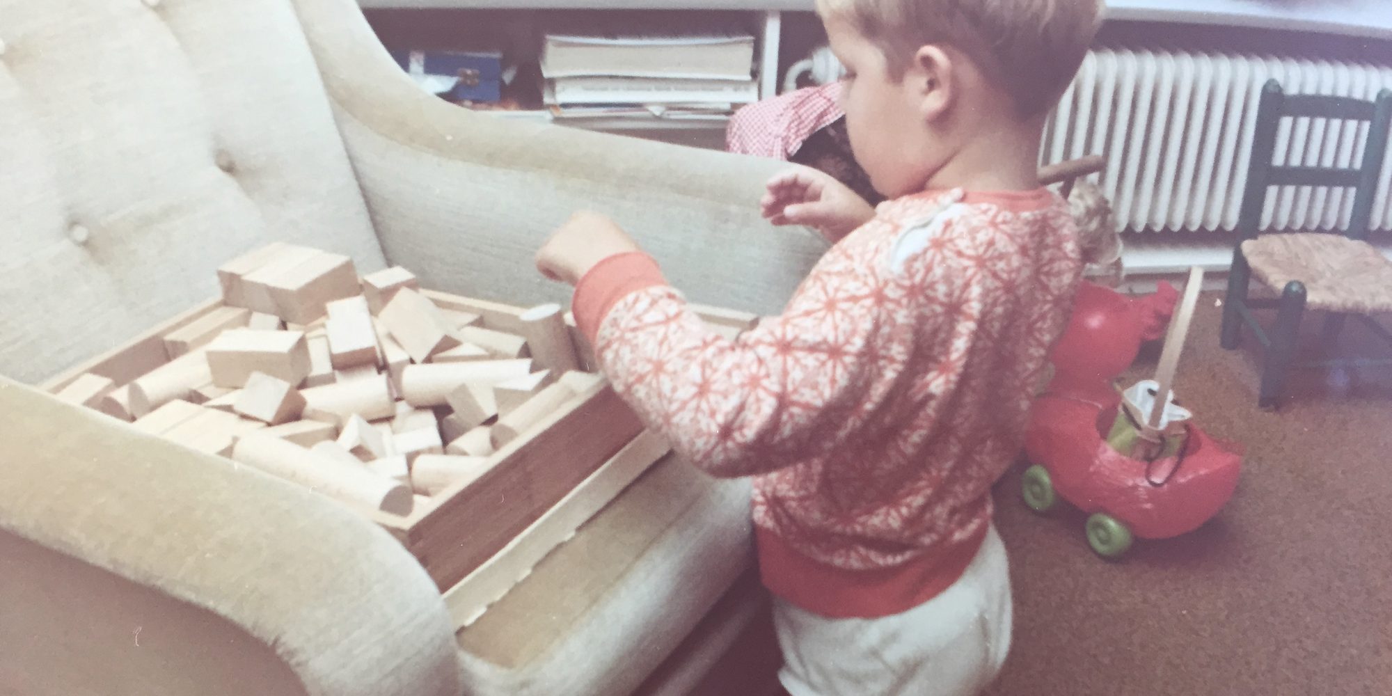 Jaco as a boy, building with a box of wooden blocks