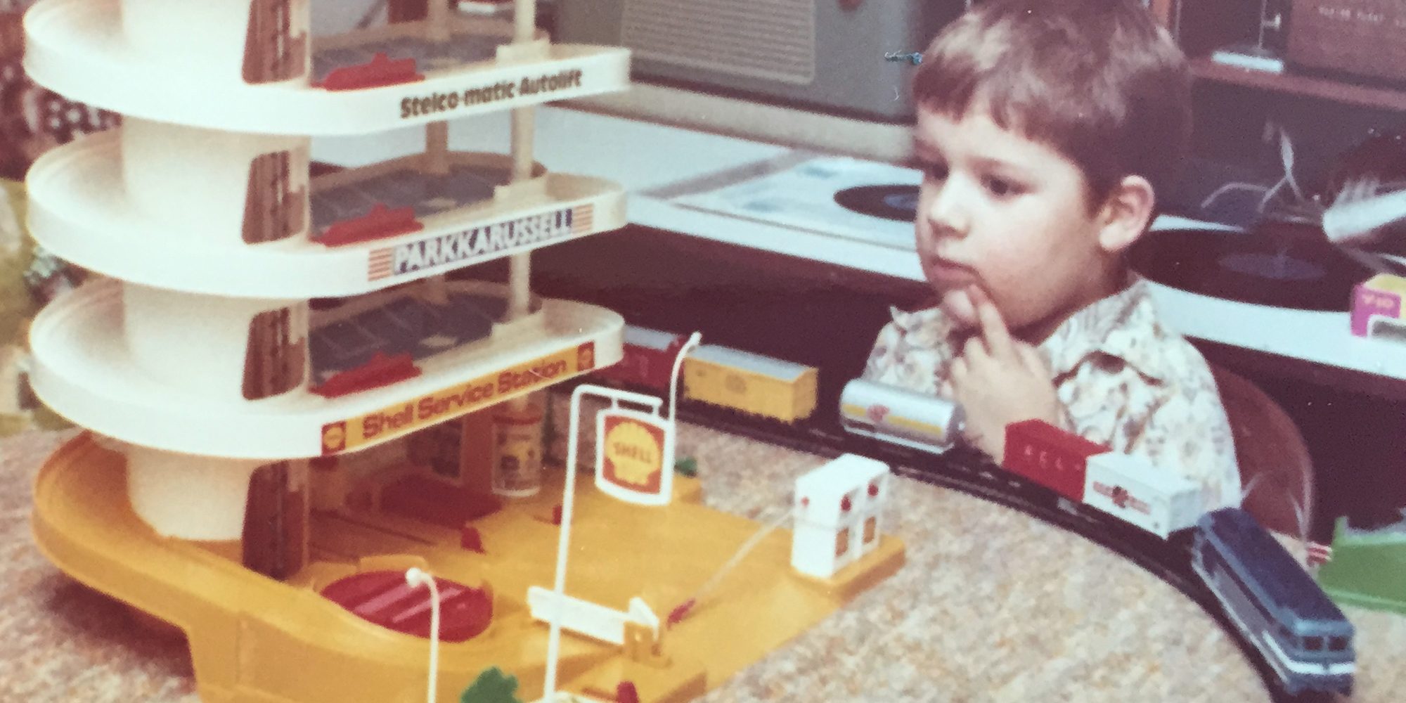 Jaco as a boy at the table with his toy garage and train track
